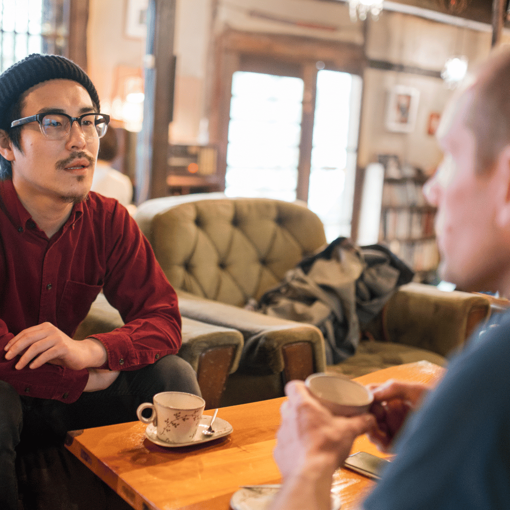 Two men sitting at a coffee table talking