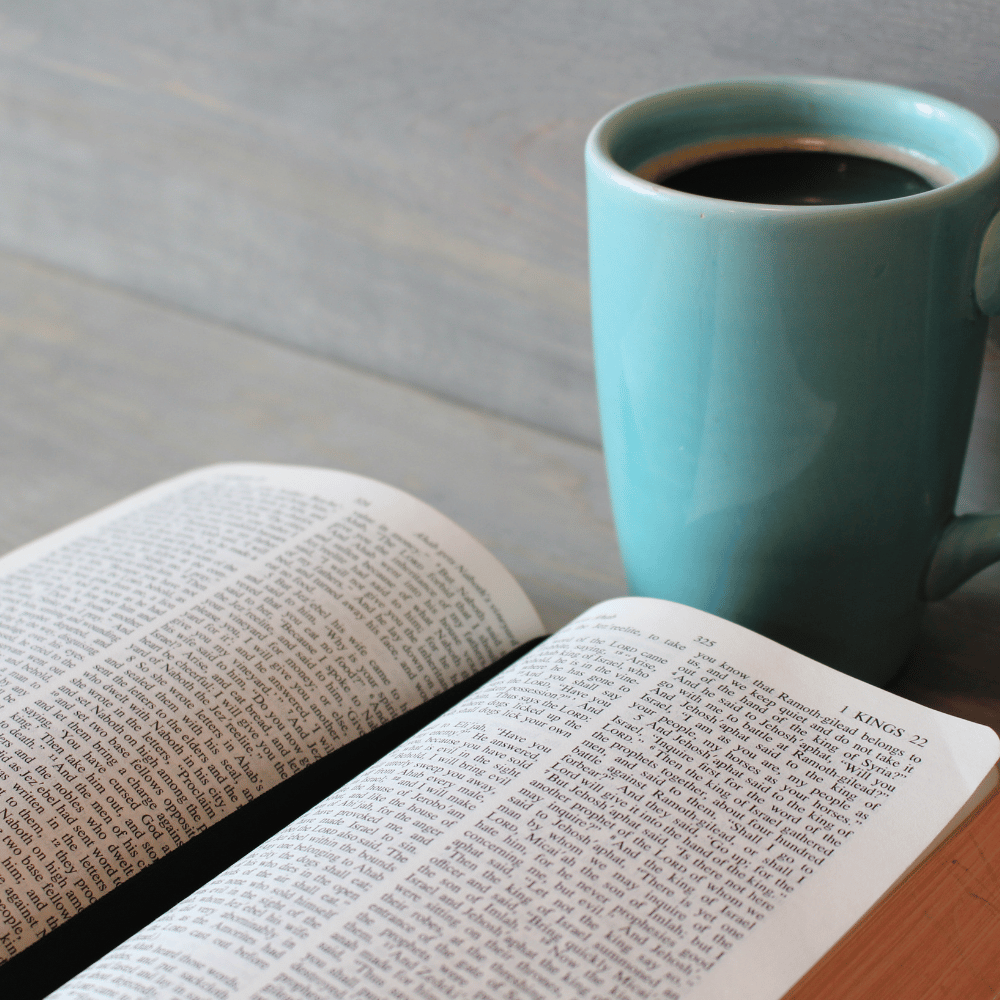 A bible with a blue coffee mug